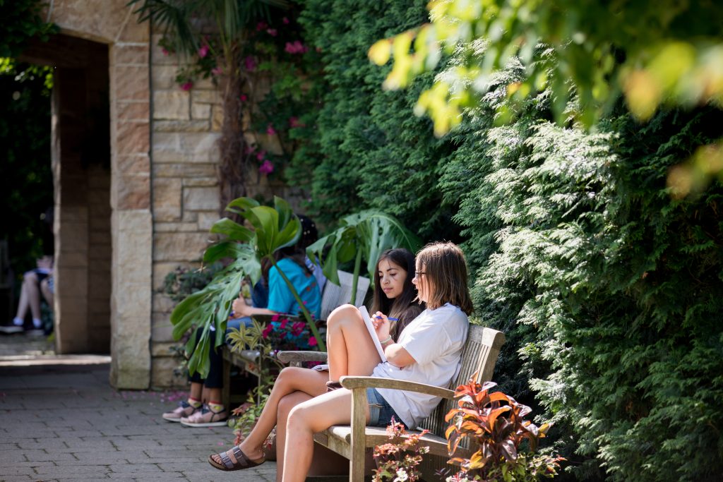 children on a bench writing